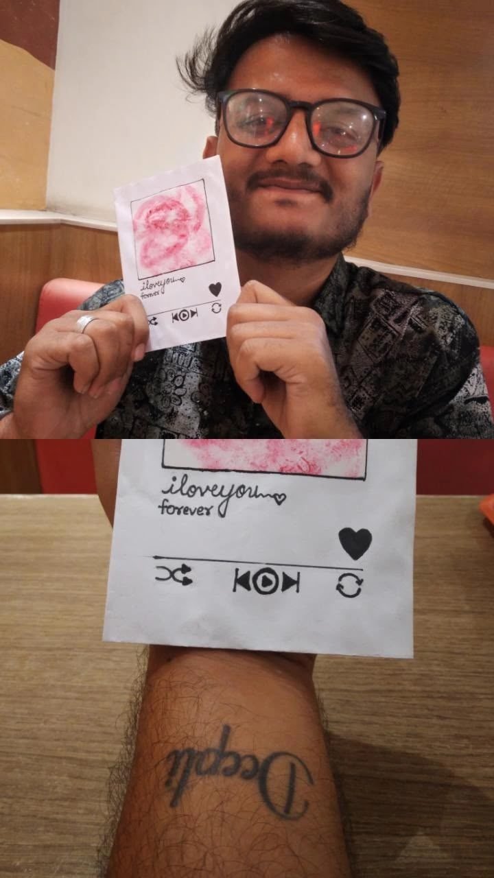Him holding a handmade card, and her name tattooed on his wrist